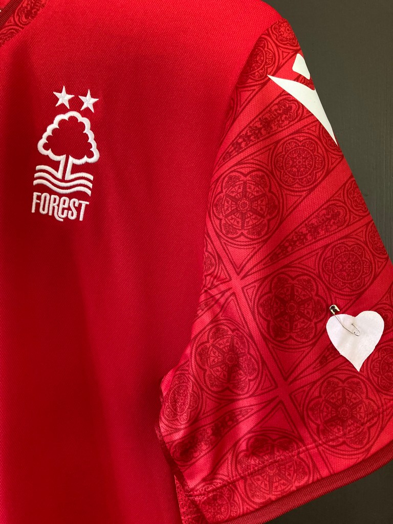 Nottingham Forest home shirt with a heart pinned to the sleeve.