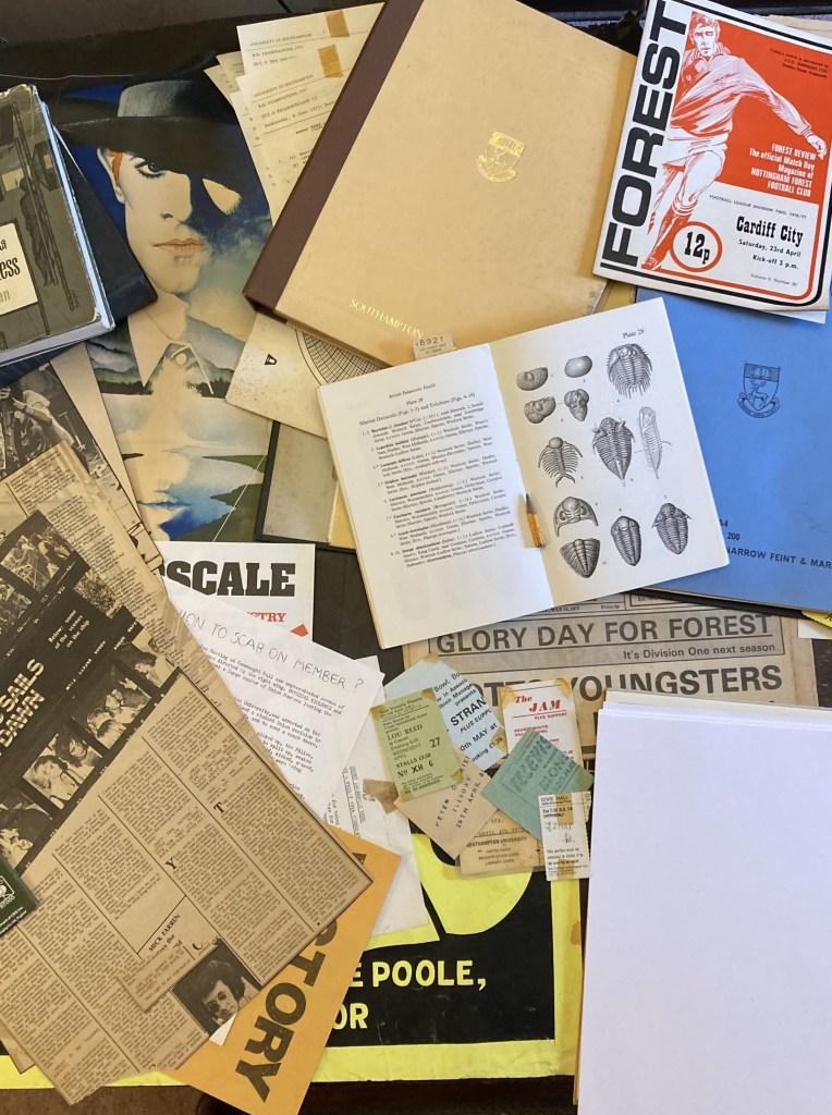 Collage: Man who Fell to Earth film poster; Southampton University folder; textbook showing trilobites; various concert tickets including Television, Jam, Peter Gabriel, & Lour Reed; Front page of Football Post "Glory Day for Forest"; various politics flyers; blank A4 notepaper.