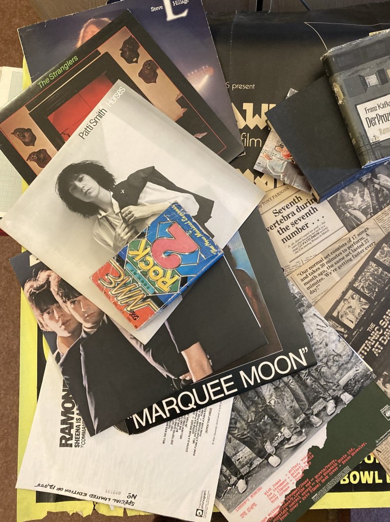 Collage: 
LPs: L (Steve Hillage); Rattus Norvegicus (Stranglers); Horses (Patti Smith); Blondie; Marquee Moon (Television); Ramones; Clash, plus Sheena is a Puck Rocker EP;
Hardback copy of Der Process (Franz Kafka);
NME article "The Titanic Sails at Dawn (Mick Farren);
