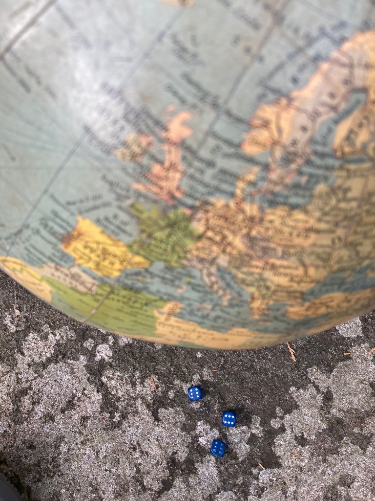 Playing dice with Earth (globe of Earth plus three dice each with 6 uppermost).