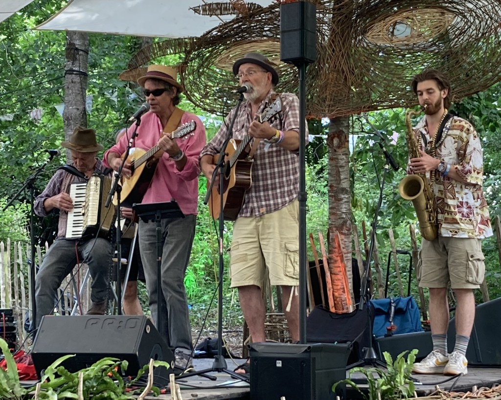 A four piece band playing on the small stage in the Woods, Glastonbury.